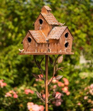 Close up image of New Britain birdhouse stake that has a square frame fence with bird perched at the top of the roof and vines growing from the stake to the birdhouse