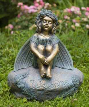 25 inch tall magnesium fairy garden statue sitting on welcome stone with closed eyes and arms around legs