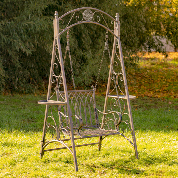 Antique bronze iron swing chair with curlicue designs on the sides
