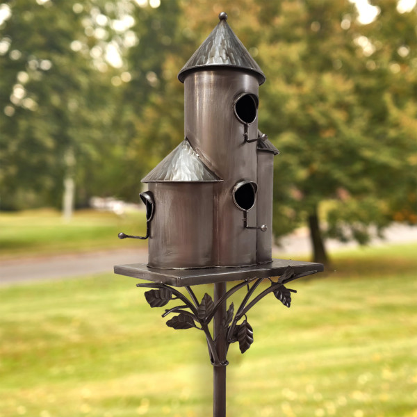 Side view of Tall cylinder birdhouse stake in a antique silver color that has a cornicle roof with holes right around for birds and vines running from the stake to the birdhouse