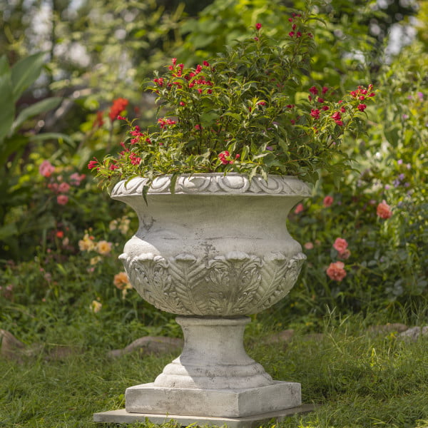 another view 31 inch tall urn flower plant in ancient Rome and Greek style in antique white with flowers inside in garden