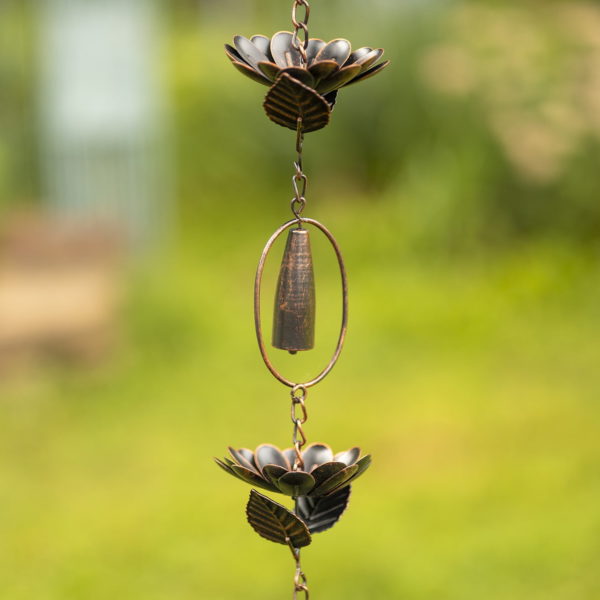 closed up image if iron rain chain with peonies and chimes in antique bronze