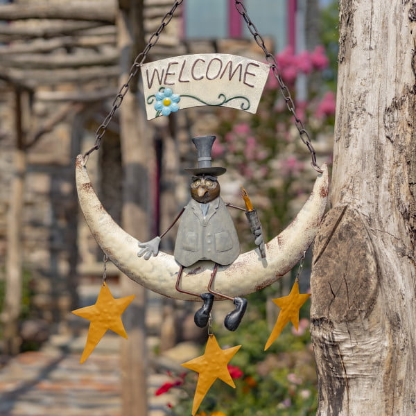 metal hanging welcome sign with moon with three stars on a chain and sitting owl in a top hat on it