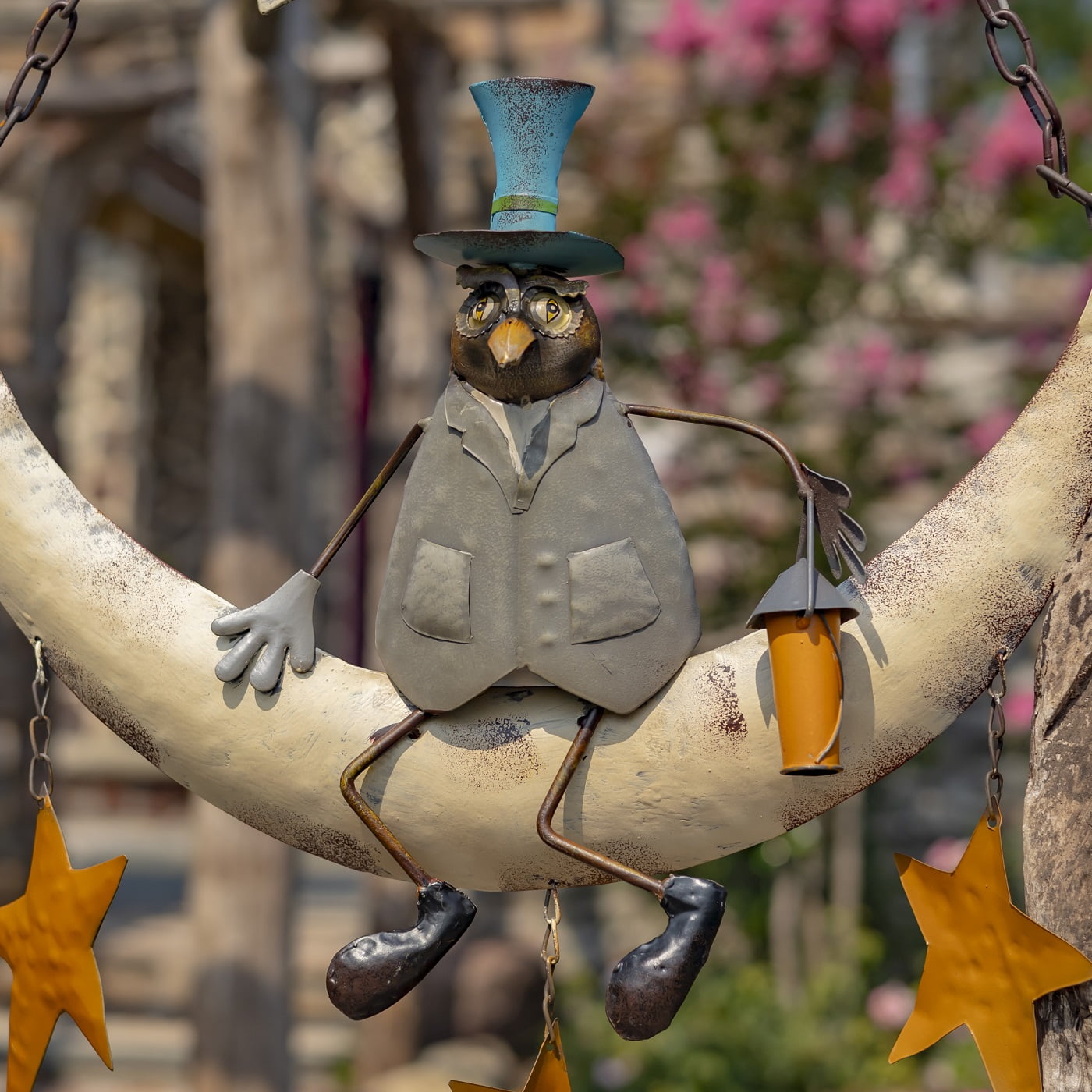 close up image of owl in blue top hat and jacket holding firework rocket and sitting on a moon with stars