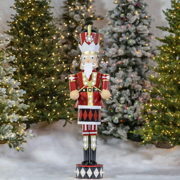 Tall large iron Christmas Nutcracker dressed professionally in his Christmas colors with his drum stocks in hands and his drum attached to his waist