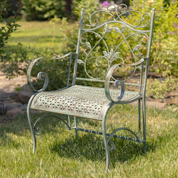Close Up of Metal Arm Chair with curved seating and Victorian Style Scrolling on Backrest