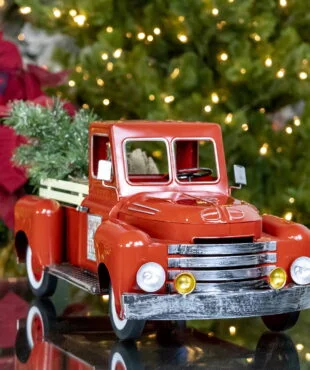 small red metal truck decoration with Christmas tree in trunk