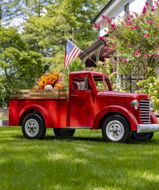 Large glossy red iron truck with LED lights and pumpkins in trunk