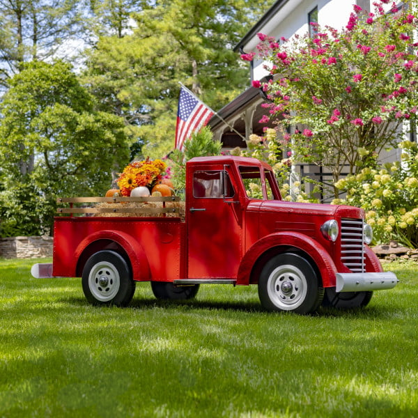 Large glossy red iron truck with LED lights and pumpkins in trunk