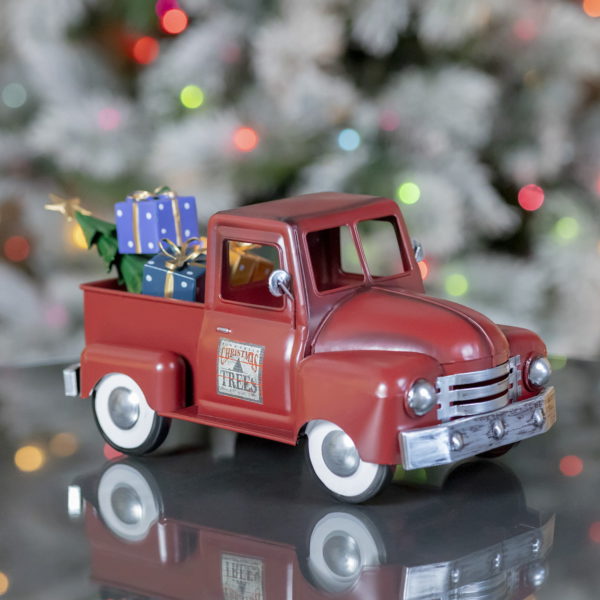 Side view of small metal Red Vintage Style Truck with Christmas gifts and trees in the back