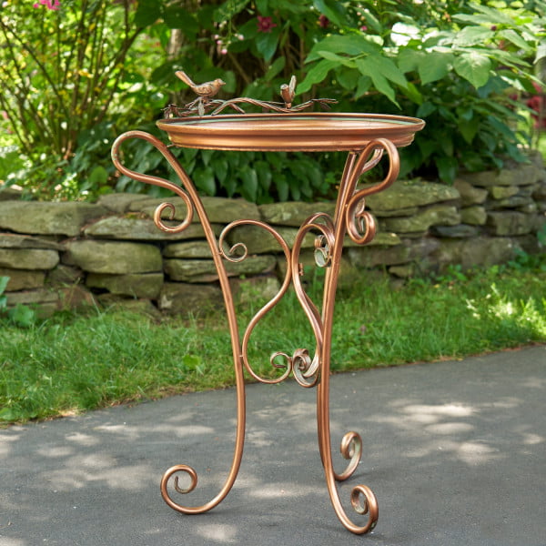 Shallow tray copper birdfeeder with three curlicue legs and two birds perched to the top of the birdfeeder