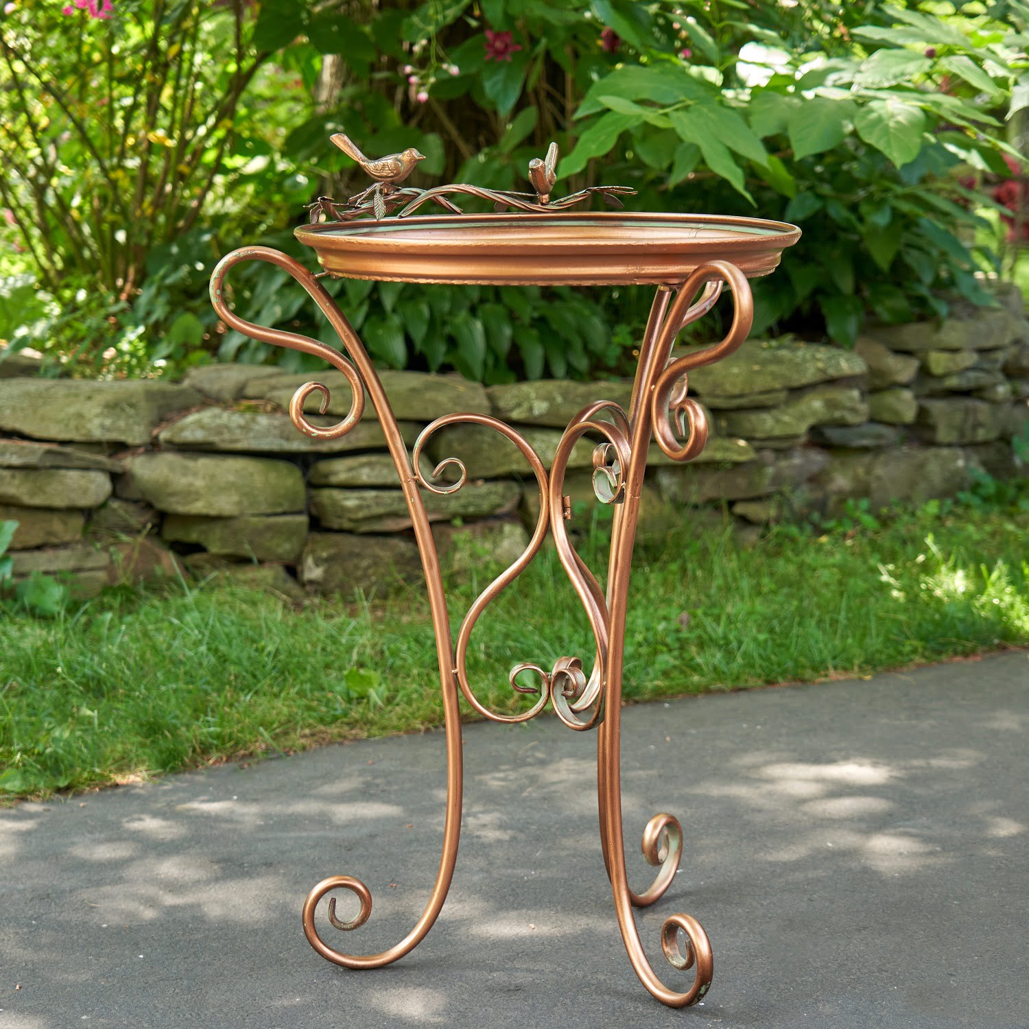 Shallow tray copper birdfeeder with three curlicue legs and two birds perched to the top of the birdfeeder