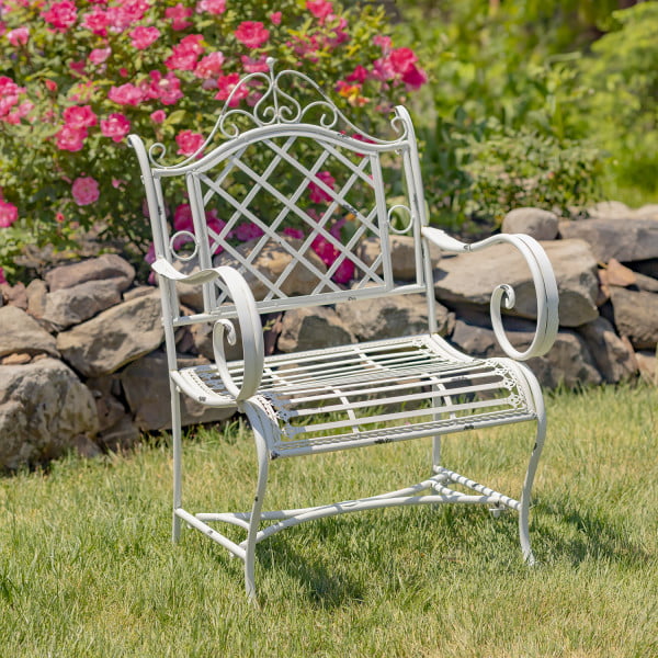 Victorian-style wrought iron garden armchair with lattice backrest and perpendicular slats of the seat with filigree details in antique white in garden