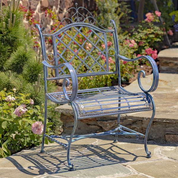 Victorian-style wrought iron garden armchair with lattice backrest and perpendicular slats of the seat with filigree details in antique blue in garden