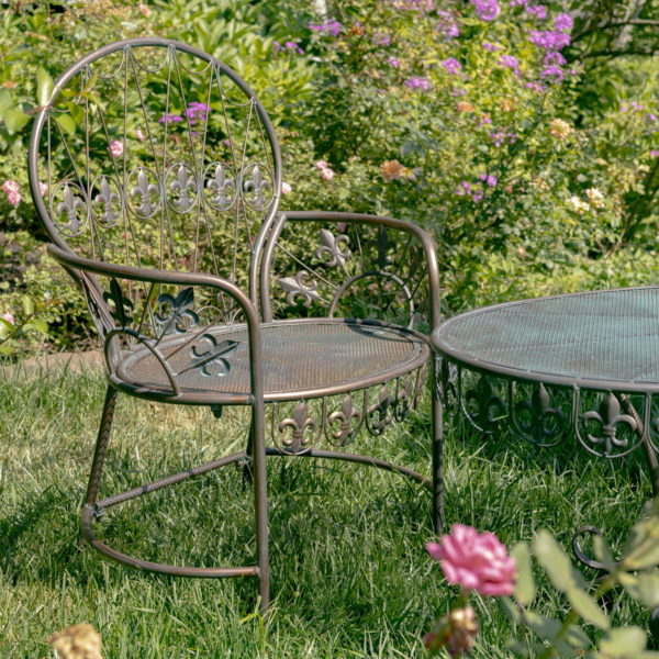 Side View of Metal Chair with Roma Like Leafing on Armrests and with a Glimpse of the Matching Table