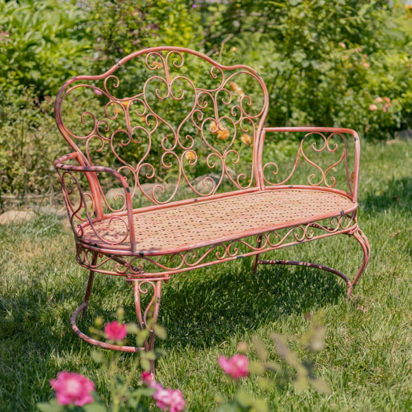Pink iron garden bench with heart shape curlicue designs