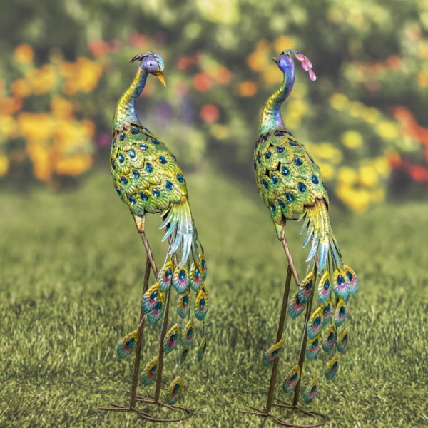 Full body view of Two Colorful Metal Peacocks in bright colors of blue and green