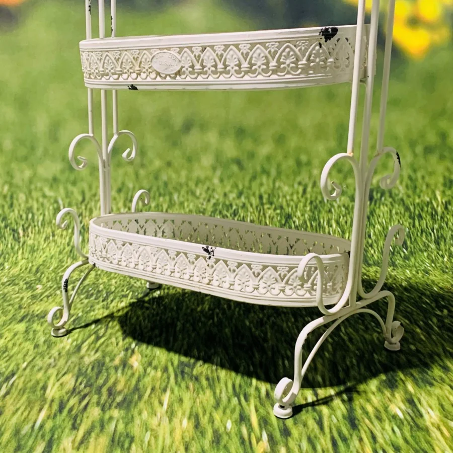 Close up image of the bottom of the Antique White Plant Stand showing you the detailed design around ever tier