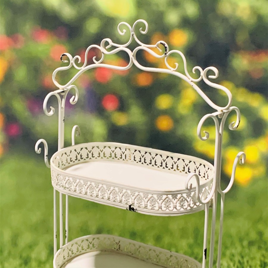 Close up image of the first tier of the Antique White Plant Stand showing you the curlicue design at the top of the item