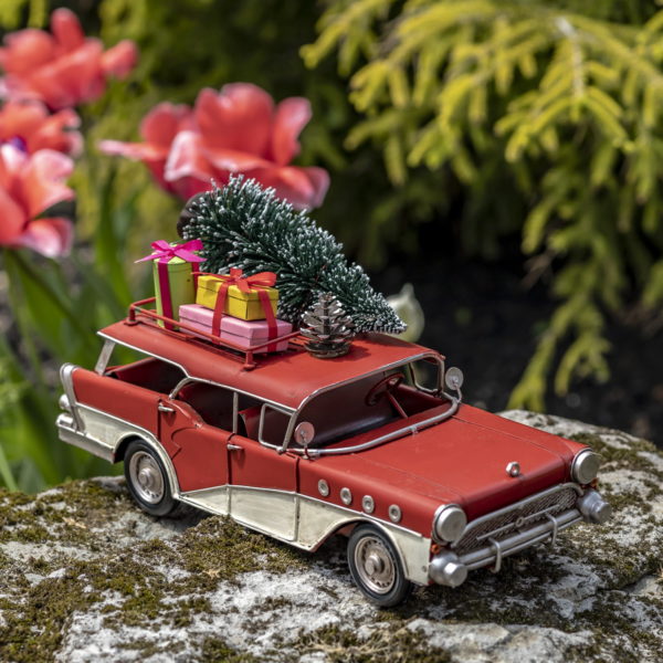 Red and Cream Colored Metal Station Wagon with Christmas Gifts and Tree Strapped to the top of the Roof