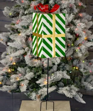37 inch tall metal green and white striped Christmas gift box stake with red metal ribbon on top of it