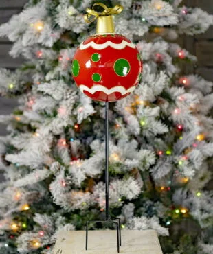 Metal Red Christmas ornament ball with green polka dots on tall black iron garden stake