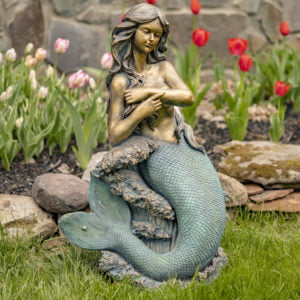 beautiful bronze mermaid garden statue sitting in rocks