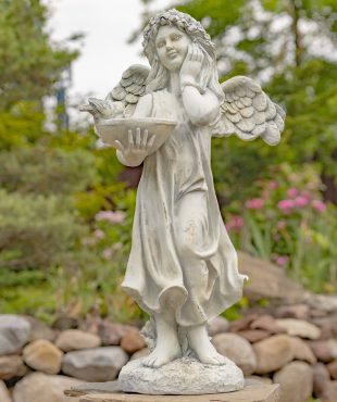 Full View of Antique White Angel with Bird Details Standing on a Rock with Rock Background