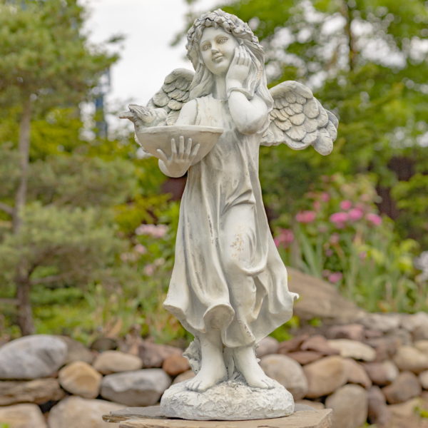 Full View of Antique White Angel with Bird Details Standing on a Rock with Rock Background