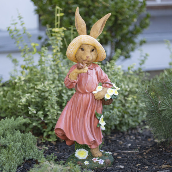 Easter decorative statue with tall lady Rabbit in reddish pink dress with her yellow hat holding a basket of flowers in one hand and in the other her little snail