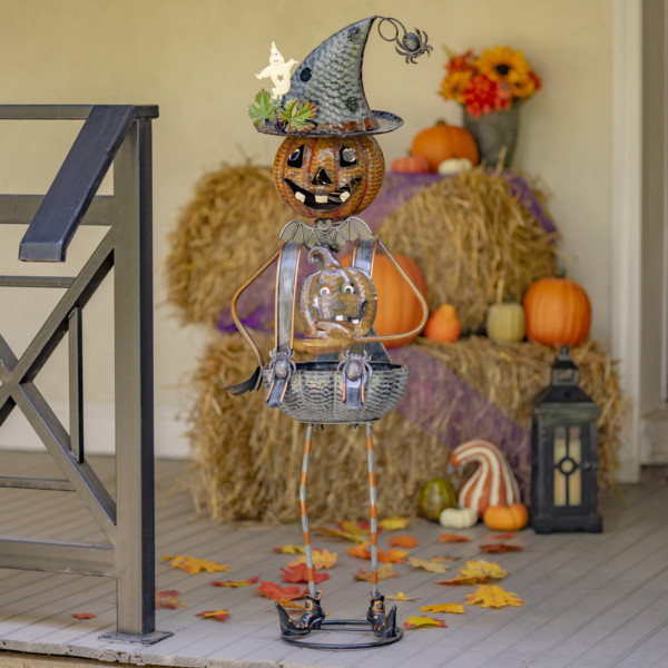 Halloween lantern decoration with tall iron pumpkin witch with inner body shaped into a candy holder standing on doorstep