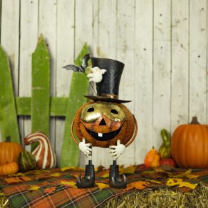 A pumpkin with a gold mask and a top hat with with a ghost and bat attached