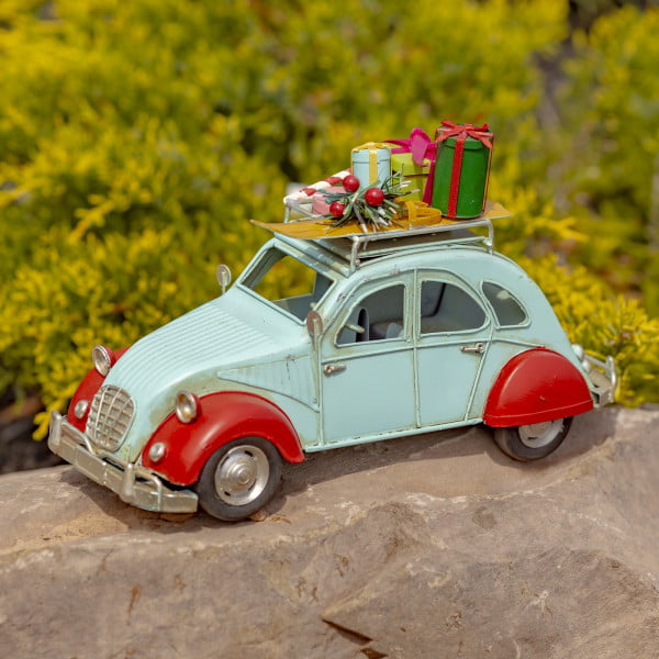 Small red and blue grey vintage buggy model with colorful Christmas gifts on the roof top of the car