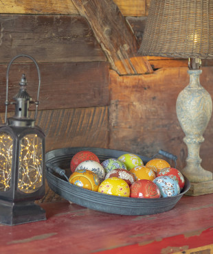 Ceramic Balls sitting in a Pant on a table in assorted colors and designs