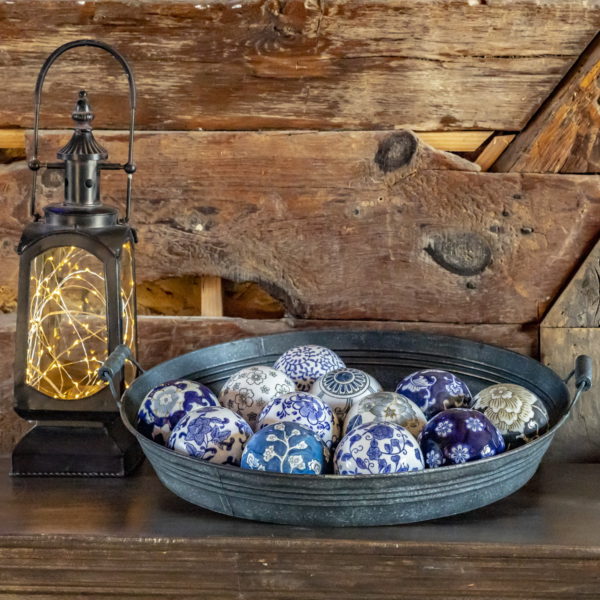 Ceramic Balls Sitting in a Tray next to a Lantern