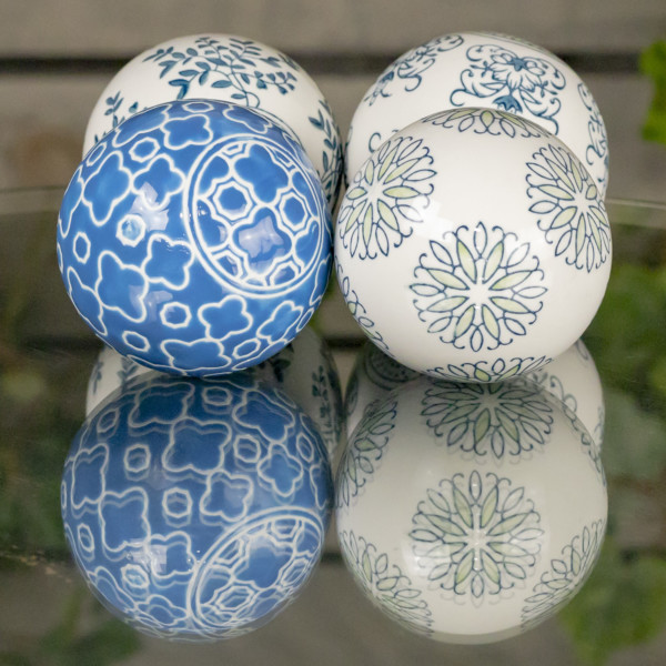Four blue,grey and navy ceramic sailor balls with floral Japanese design