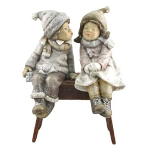 Christmas -Children Sitting on a bench kissing with hats and coats on