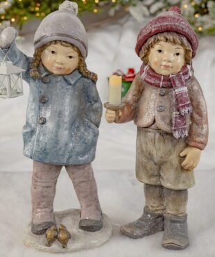 A Girl and Boy - Holding a Lantern, Candles- Has two birds sitting at their Feet and they are Wearing Winter Clothing