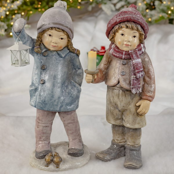 A Girl and Boy - Holding a Lantern, Candles- Has two birds sitting at their Feet and they are Wearing Winter Clothing