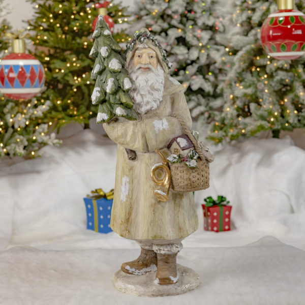Full View of Santa Statue Wearing Grey Coat- Holding a Basket Filled with Gifts and a Christmas Tree