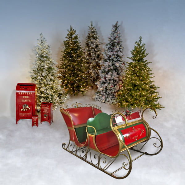 large four person Christmas sleigh with glossy red and hunter green finish and metallic gold trim with ornate design and runners, 3 red mailboxes and 5 Christmas trees on a background