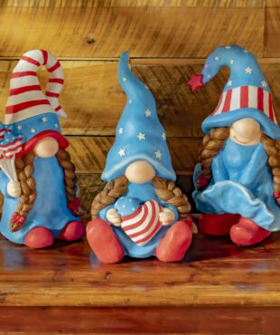Three assorted American lady patriot garden gnomes with all three of them in the american colors with there two braids flowing down there chest