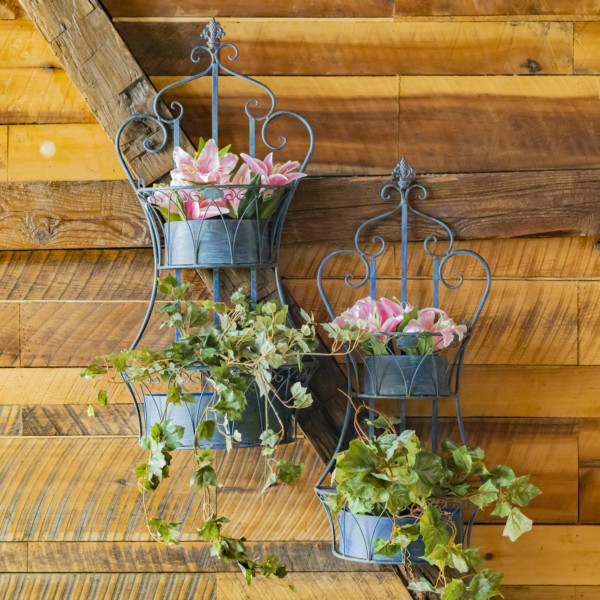 Two dual blue hanging iron basket planters with curlicue designs and plants in it for additional décor ( Plants not included)