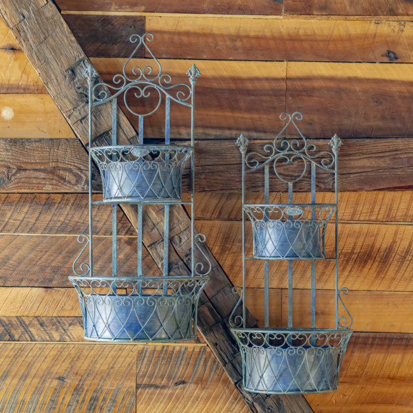 One set of blue hanging wall planters with removeable baskets and has curlicue designs on the top and in the two places where the removable baskets goes