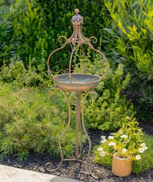 Tall standing bronze iron birdbath with brown ceramic floral designed ball with curlicue folding legs