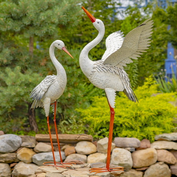 A Pair of Iron Herons with Ombre White and Dark Feathers in garden