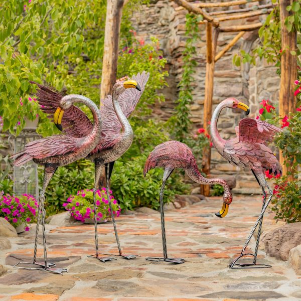 4 metallic pink flamingo garden sculptures in assorted styles in garden