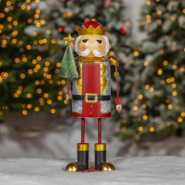 galvanized metal Christmas nutcracker figurine wearing crown and holding Christmas tree
