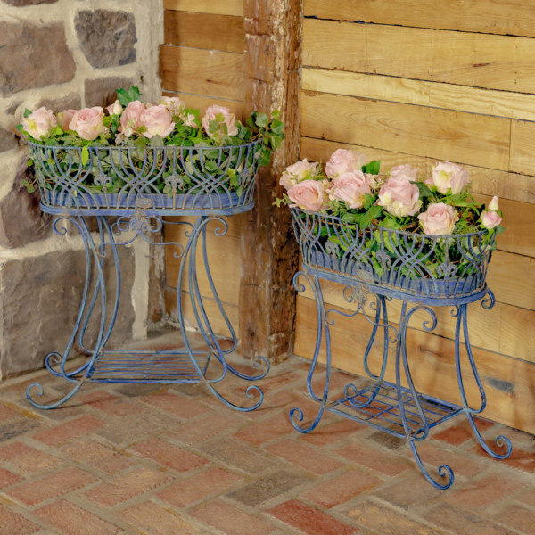 One large and one medium size antique blue oval iron basket plant stands with curlicue designed legs with plants place in them ( Plants not included )