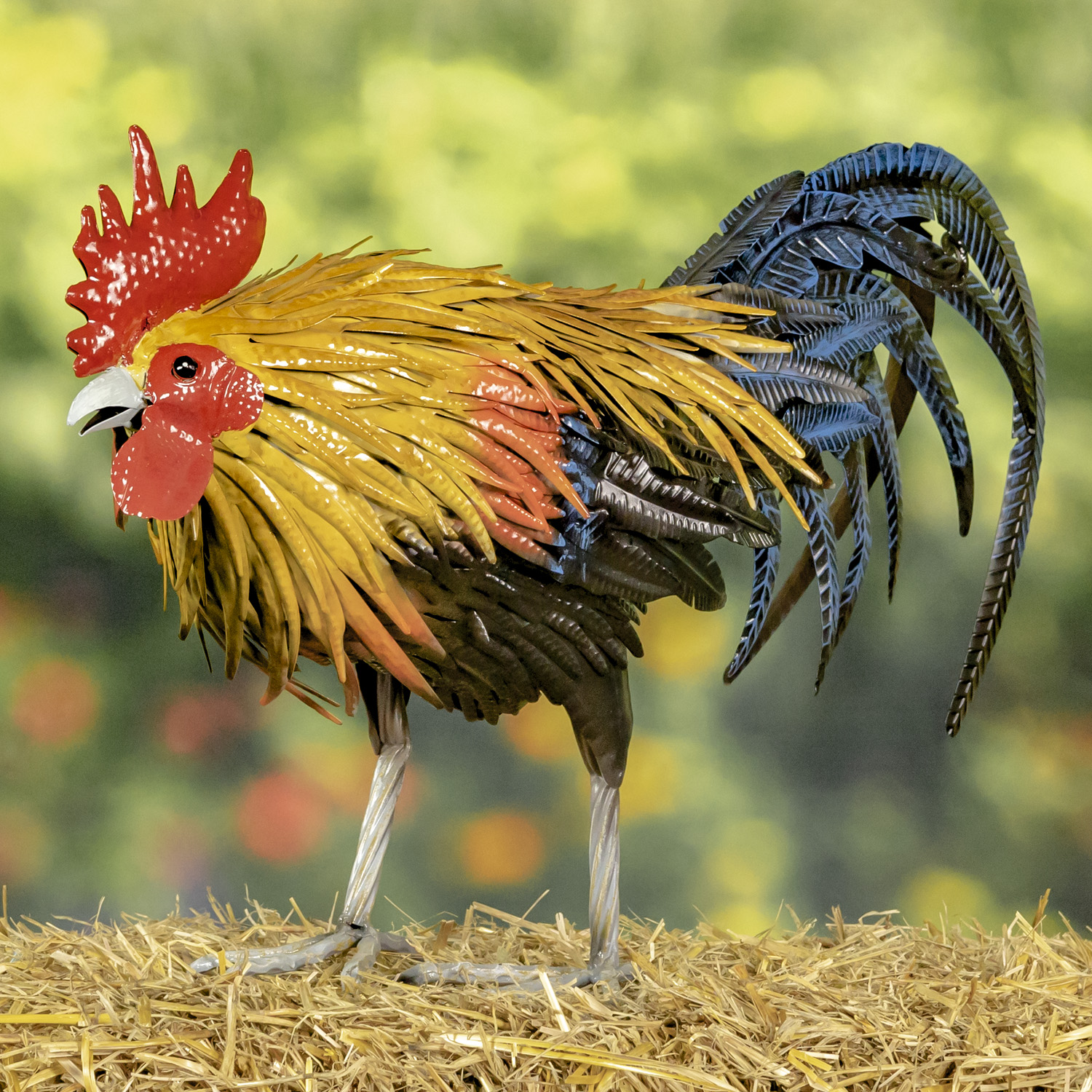 Tall iron rooster figurine leaning down as if to eat seed from the ground with his red comb on his head with his bright yelow feathers flowing down his back and his black and blue sickle feathers behind him